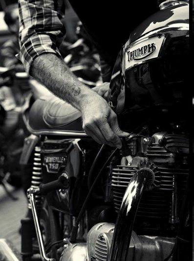 man checking spark plug on triumph motorcycle