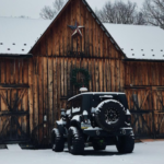 jeep parked outside wood barn with snow