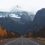 long highway leading to snow capped mountain