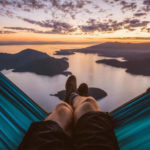 man relaxing in hammock looking at beautiful sunset