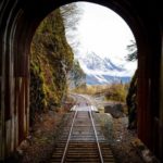railroad track and tunnel with mountain