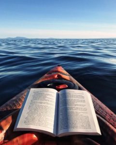 reading while rowing in a canoe