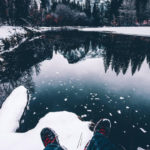 relaxing in the snow at the edge of a mountain lake
