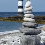 zen rocks in front of lighthouse
