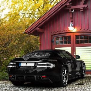black bently parked near red barn