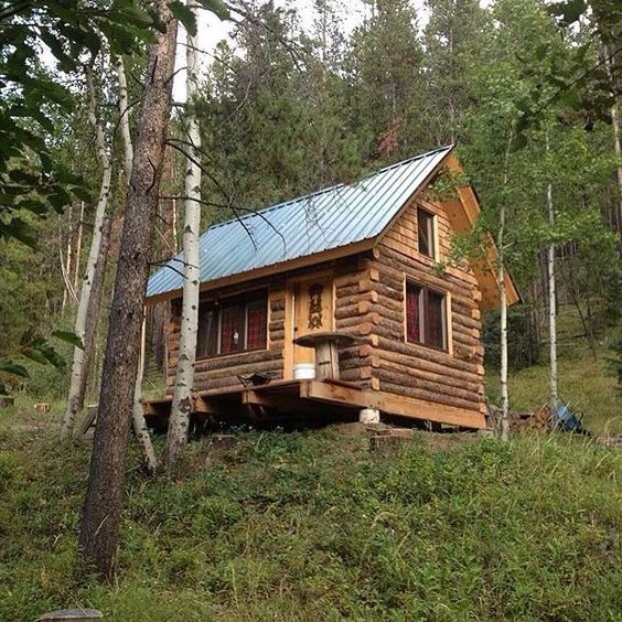 little log cabin on a hill