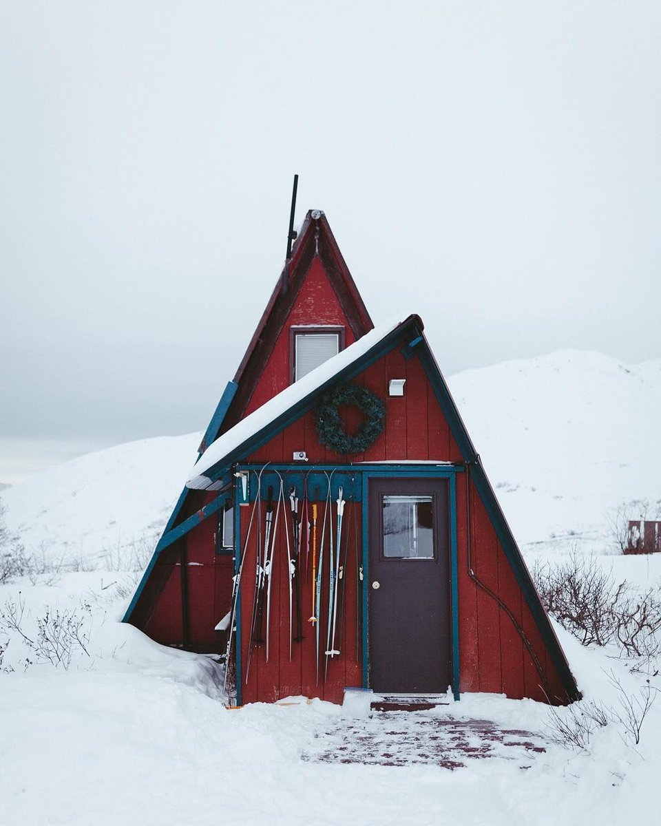 red christmas cabin in snow