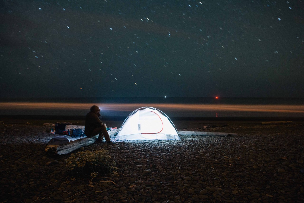 glowing tent on beach at night