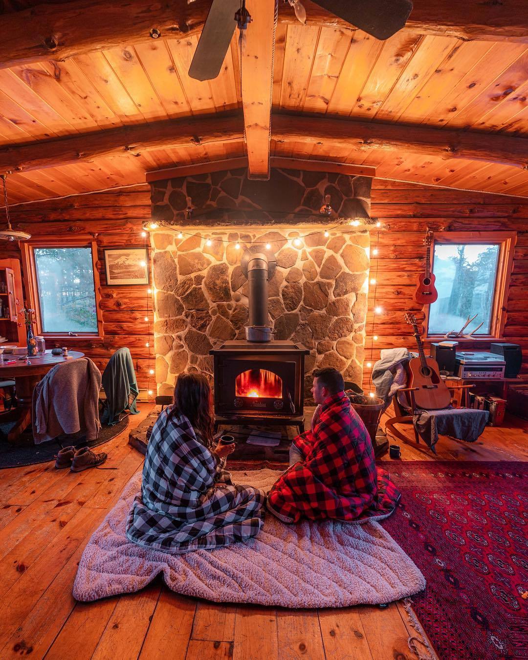 man and woman in front of wood burning stove cozy
