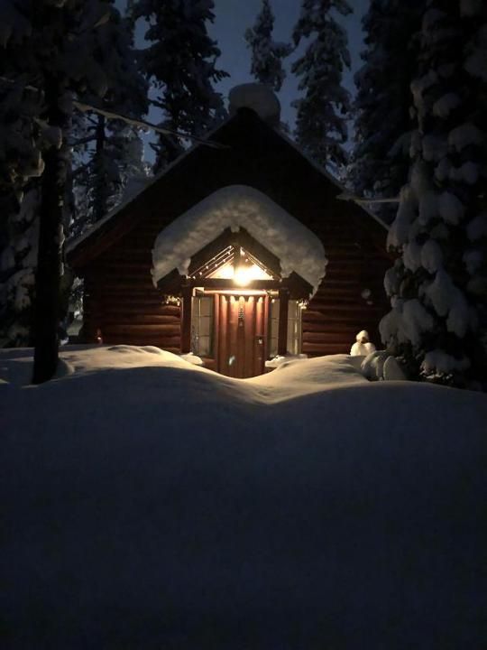 snow covered cabin in the woods