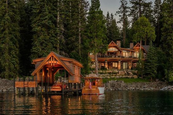 large rustic lake home with covered dock and boat
