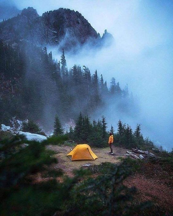 man standing near mountain campsite