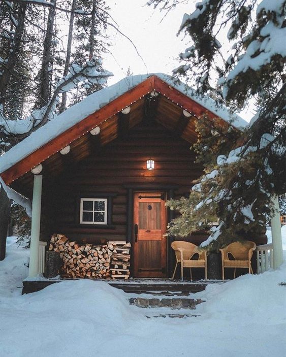 winter cabin with firewood on porch