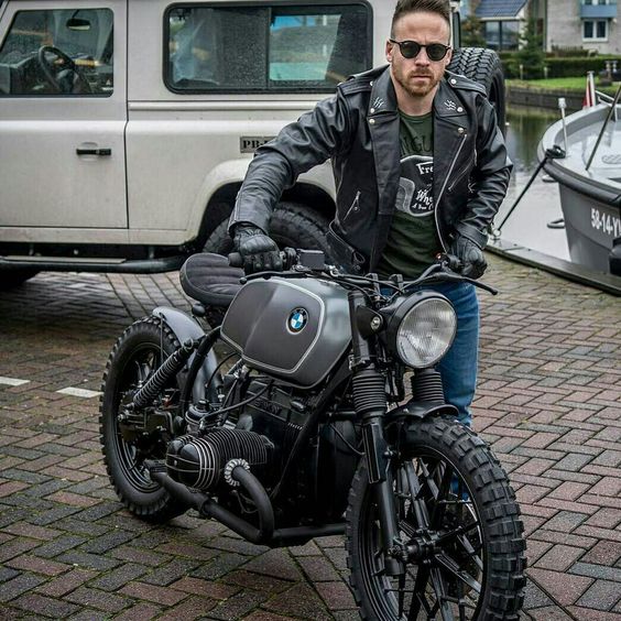 man standing next to bmw motorcycle