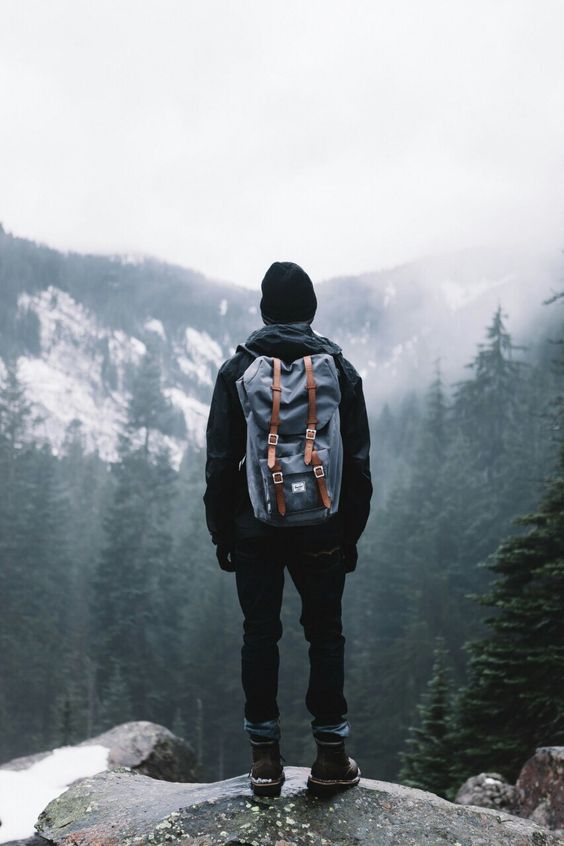 man standing on edge of mountain