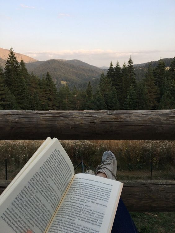 reading on deck with mountain scenery