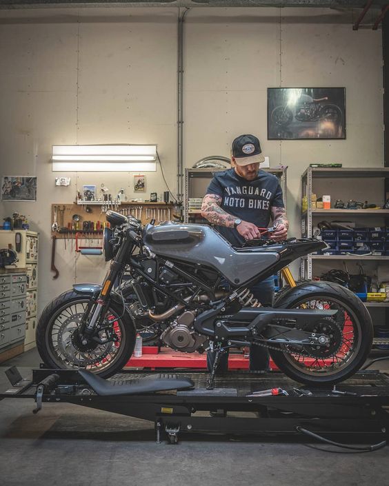 man working on motorcycle in shop