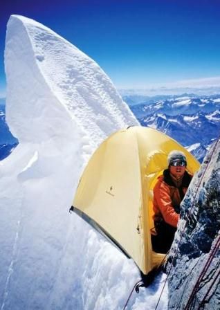 mountain climber on mountain with tent