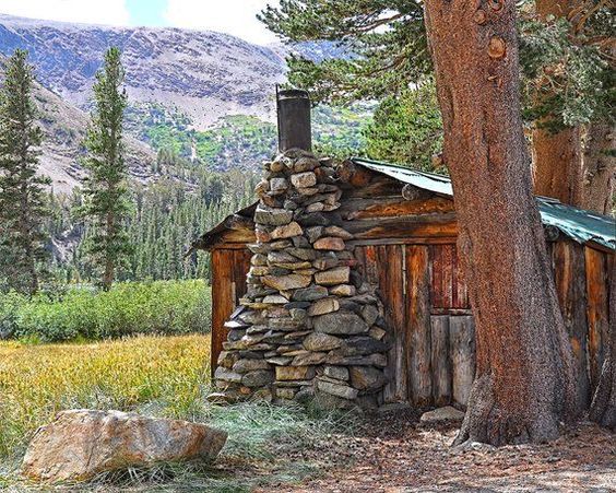 rugged and rustic little wood cabin with stone fireplace