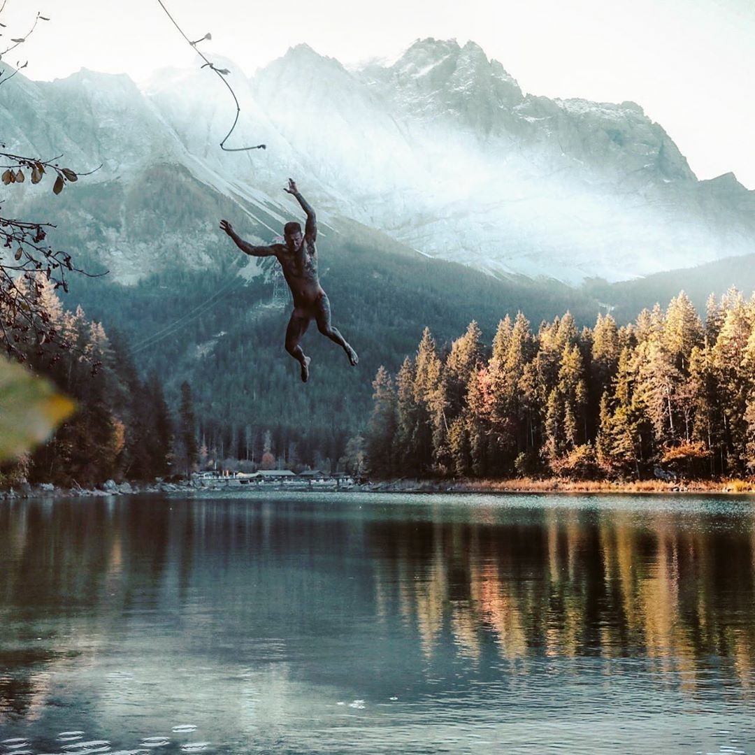 man swinging into lake