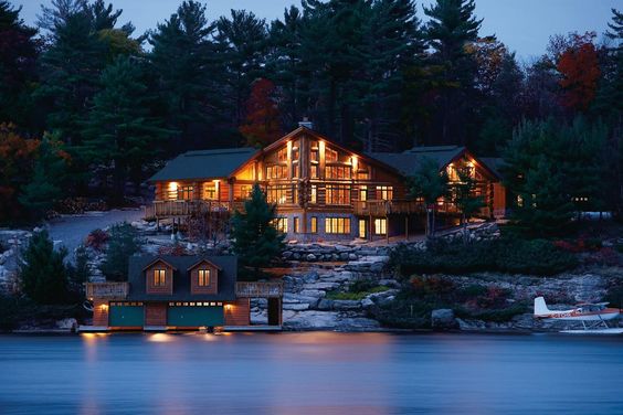 Lakeshore log cottage mansion with airplane and boathouse