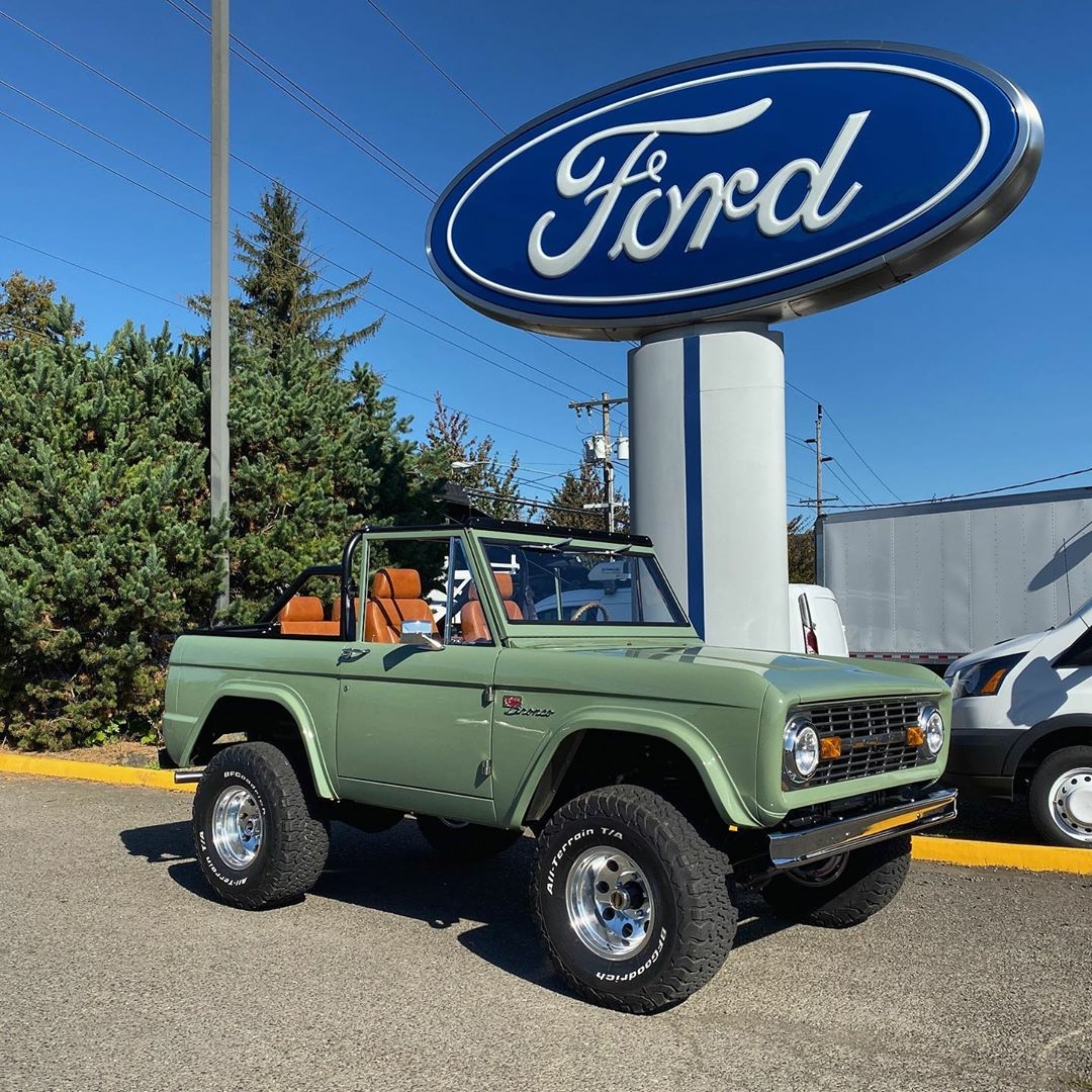 classic green ford bronco near ford sign