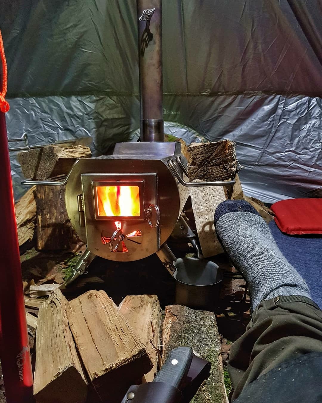 man in tent with stove