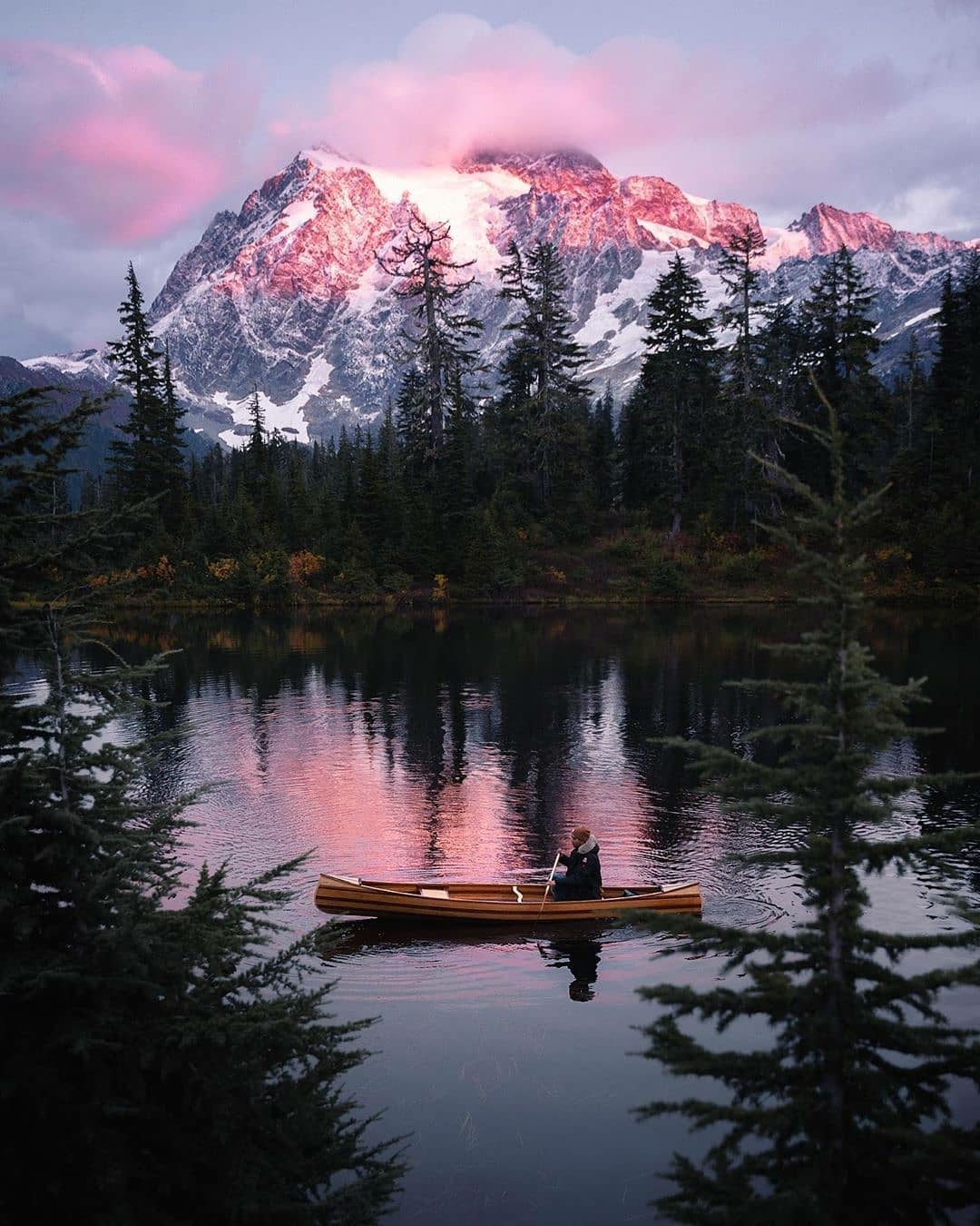 man in canoe on mountain lake