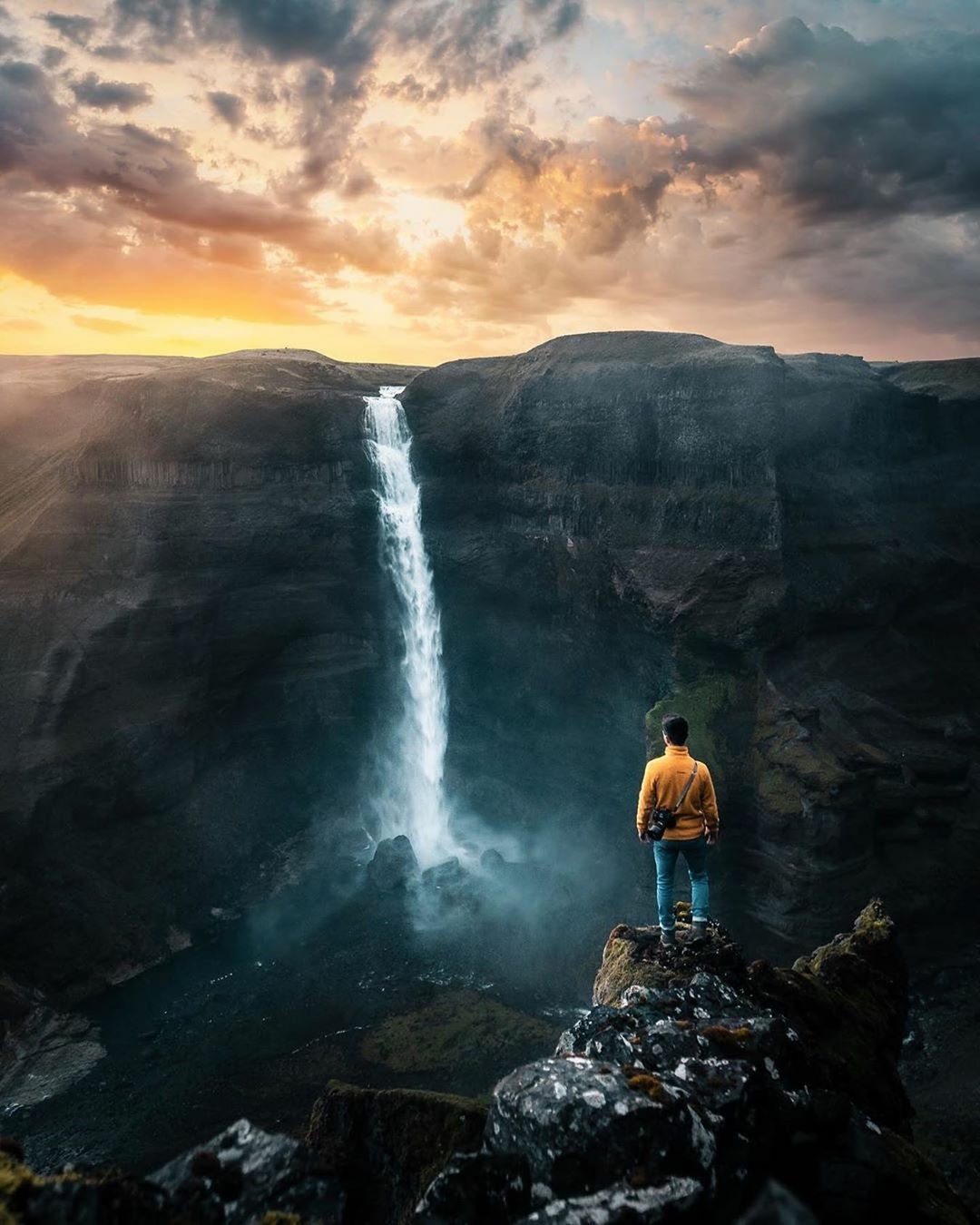 man standing near waterfall