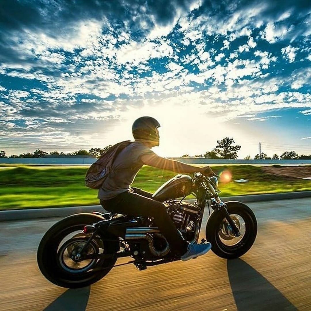 man riding motorcycle sunset